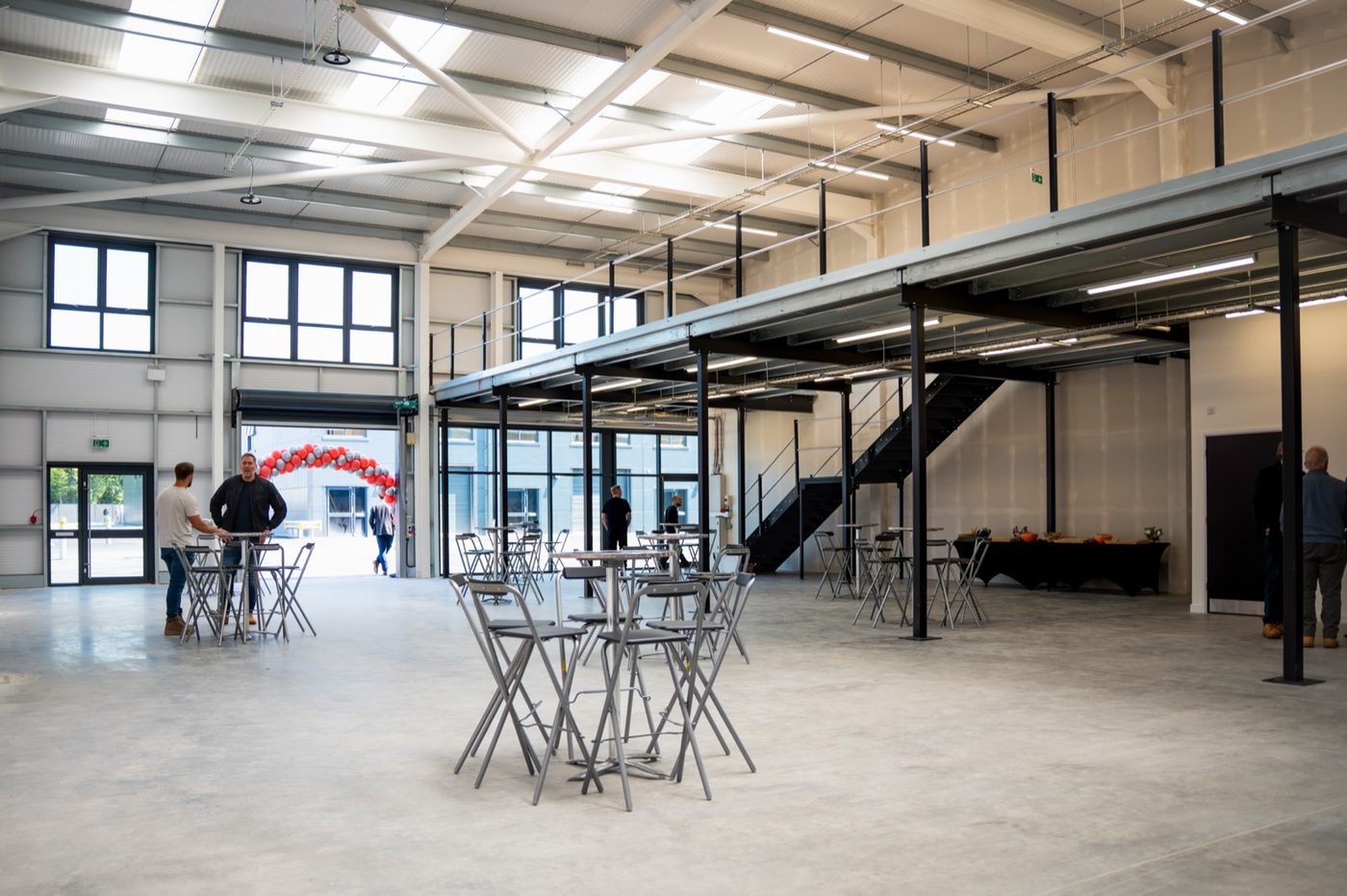 Inside a unit at the launch: mezzanine, roller door, full-height glazing
